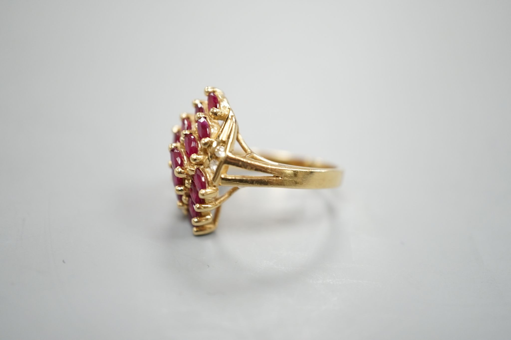 A modern 14k yellow metal ,ruby and diamond cluster set dress ring, size M, gross weight 5 grams.